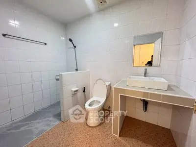 Spacious modern bathroom with sleek white tiles and contemporary fixtures.