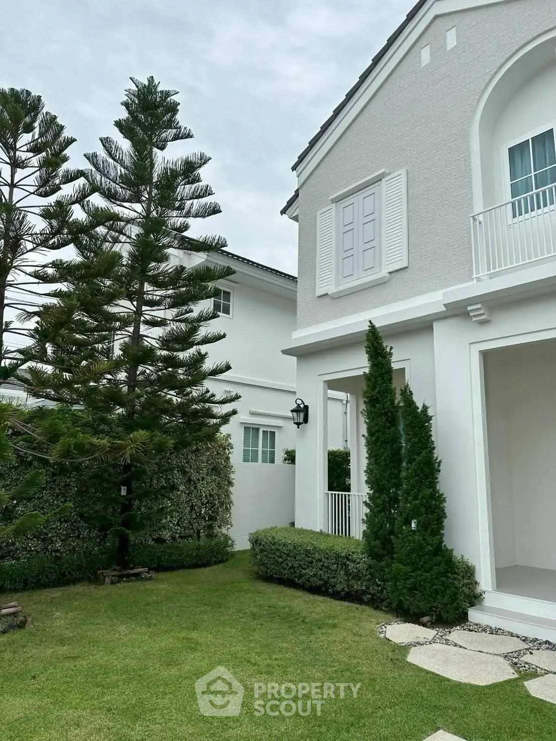 Charming white house with lush garden and elegant architecture