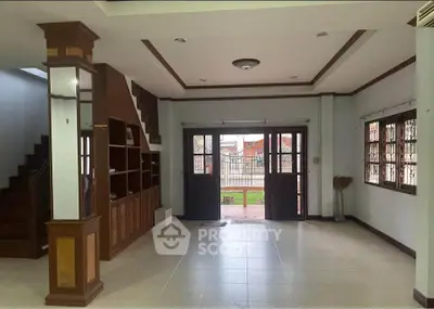 Spacious living room with elegant wooden accents and large windows offering natural light.