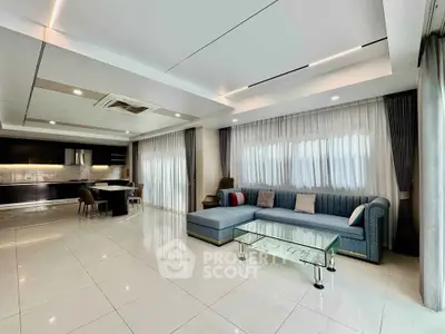 Spacious modern living room with elegant sofa and open kitchen layout