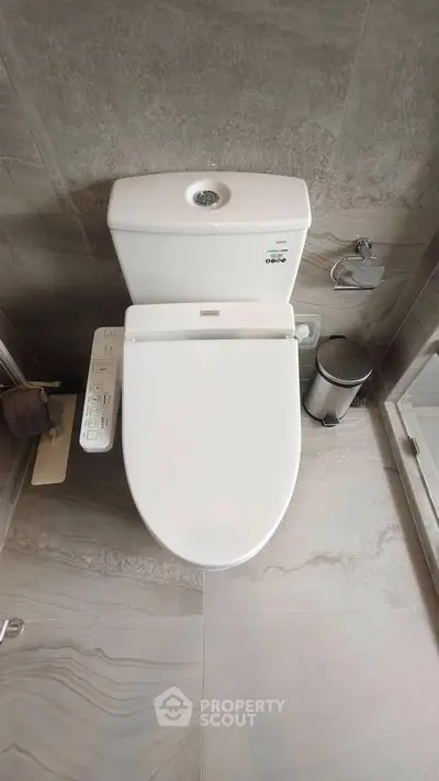 Modern bathroom with sleek toilet and neutral tile design