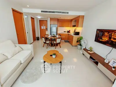 Modern open-plan living room with kitchen, stylish furniture, and bright ambiance.