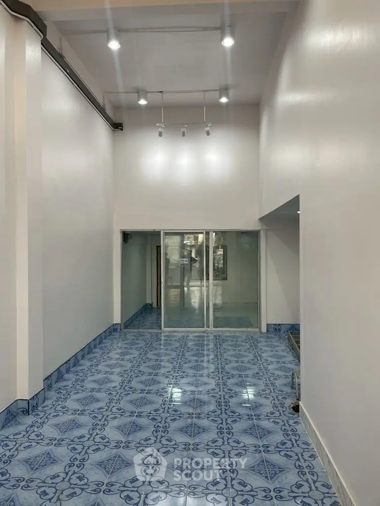 Spacious interior with high ceiling and elegant blue patterned floor tiles