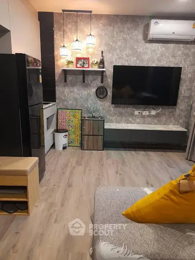 Modern living room with stylish decor, large TV, and cozy seating area.