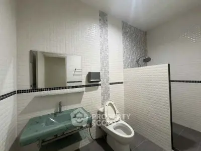 Modern bathroom with stylish green sink and open shower design
