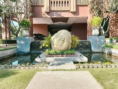 Elegant entrance with serene sculpture and lush landscaping