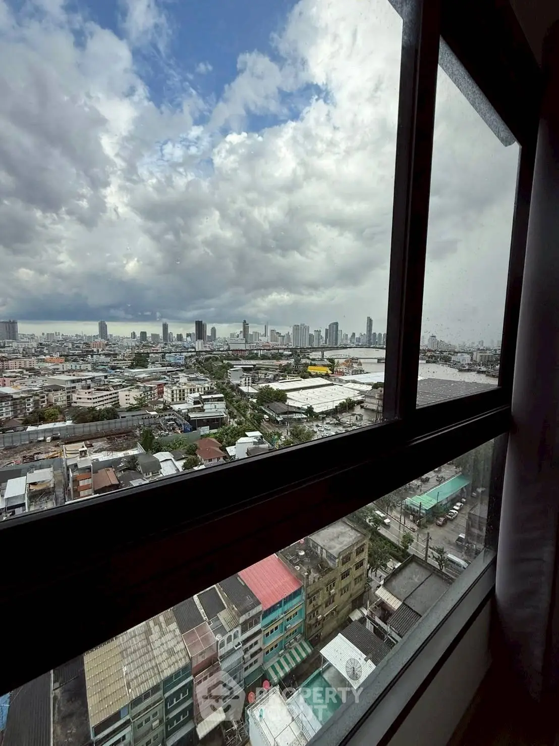 Stunning cityscape view from high-rise apartment window with expansive skyline and urban landscape.