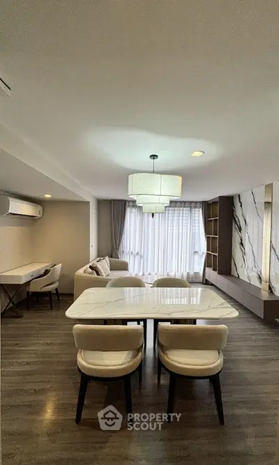 Modern living room with elegant dining area and stylish lighting, featuring a cozy sofa and chic decor.