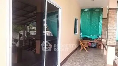 Spacious balcony with sliding glass doors and outdoor seating area.