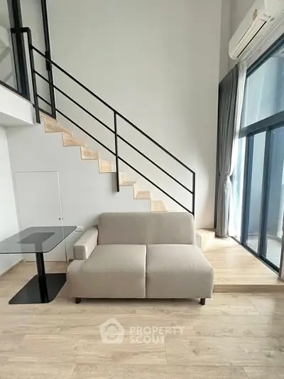 Modern living room with loft-style staircase and large windows