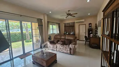 Spacious living room with garden view and cozy seating area in modern home.