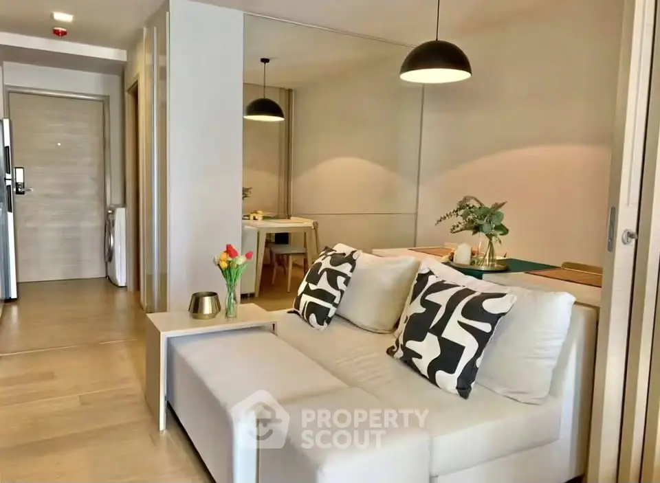 Modern living room with stylish decor and open layout, featuring cozy seating and elegant lighting.