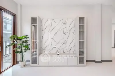 Modern minimalist living room with marble accent wall and natural light