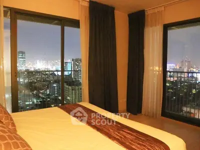 Luxurious bedroom with stunning city view from high-rise apartment balcony.