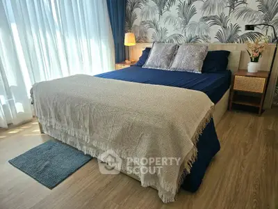 Spacious bedroom with stylish decor and natural light, featuring a cozy bed and elegant wallpaper.