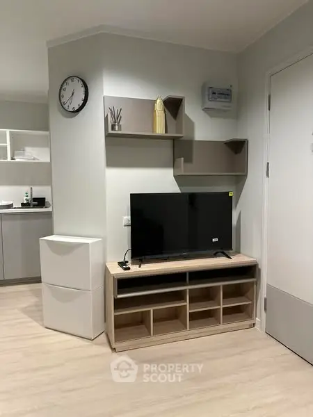 Modern living room with sleek TV stand and wall shelves in a stylish apartment.
