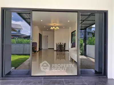 Modern home with spacious open living area and large glass doors leading to a lush garden.