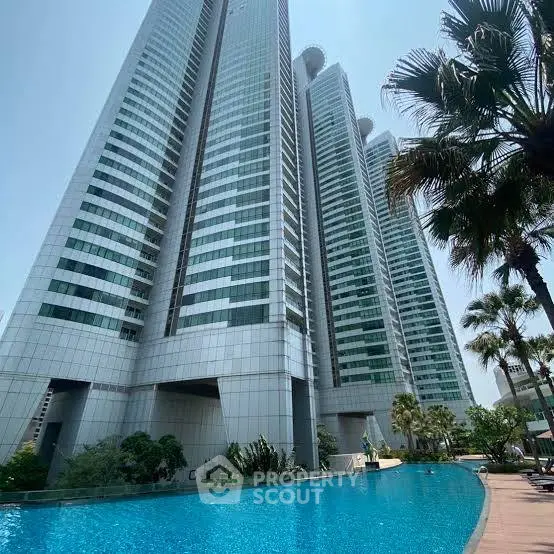 Luxurious high-rise building with stunning pool and lush greenery