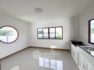 Bright kitchen with modern sink and unique round window design