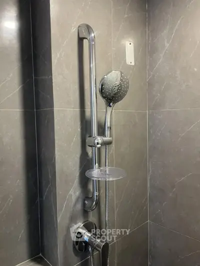 Modern bathroom shower with sleek chrome fixtures and gray marble tiles