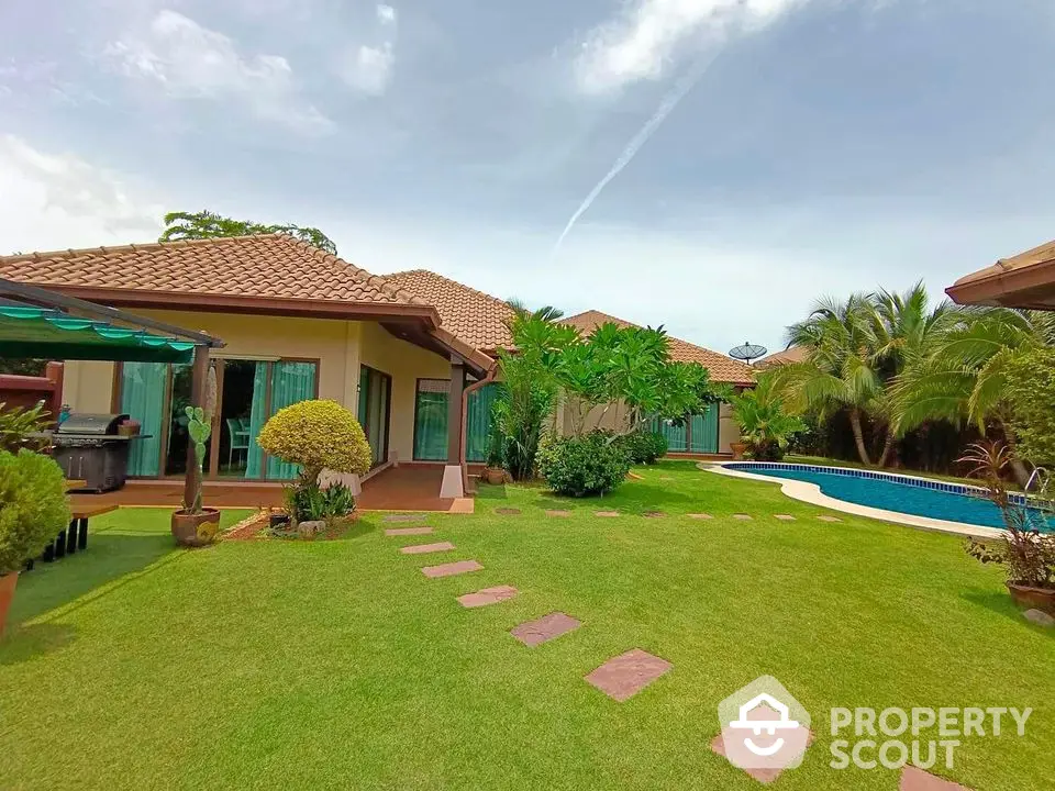 Luxurious villa with lush garden and private pool in tropical paradise setting.