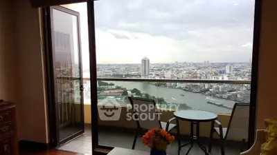 Stunning cityscape view from a high-rise balcony with cozy seating area.