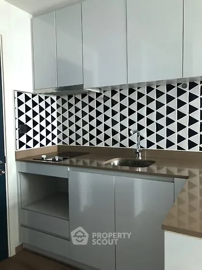 Modern kitchen with geometric backsplash and sleek cabinetry