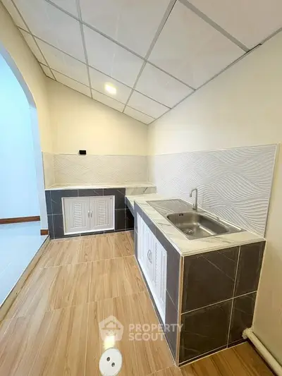 Modern kitchen with sleek design and open layout, featuring stylish backsplash and ample counter space.