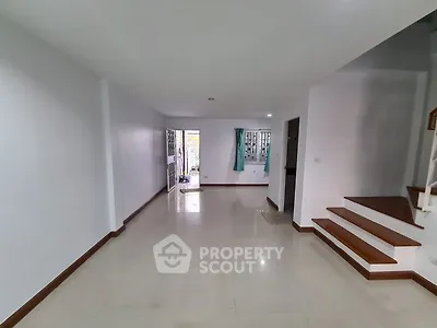 Spacious empty living room with staircase and tiled floor