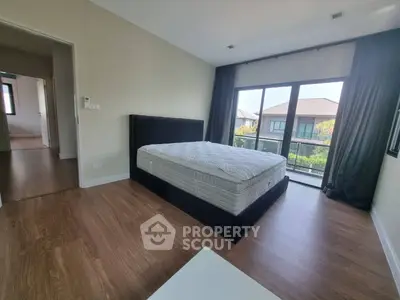 Spacious bedroom with large windows and balcony view in modern home