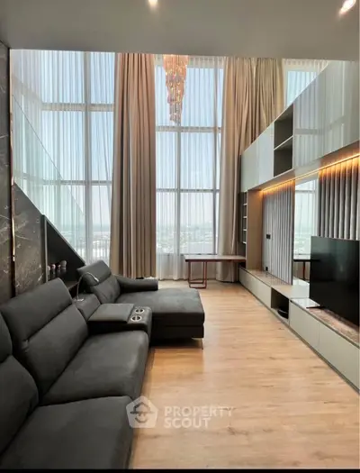 Luxurious living room with high ceilings, modern furniture, and large windows offering stunning views.