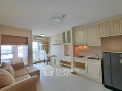 Spacious open-plan living room with kitchen and balcony view in modern apartment.