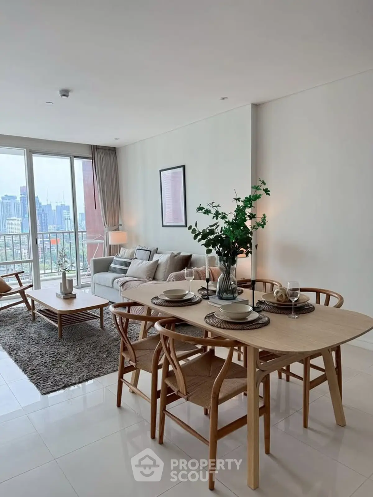 Spacious modern living room with dining area and city view, featuring elegant decor and natural light.
