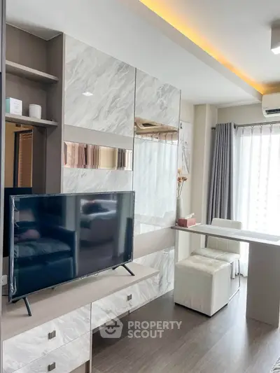 Modern living room with sleek TV setup and stylish decor in a contemporary apartment.