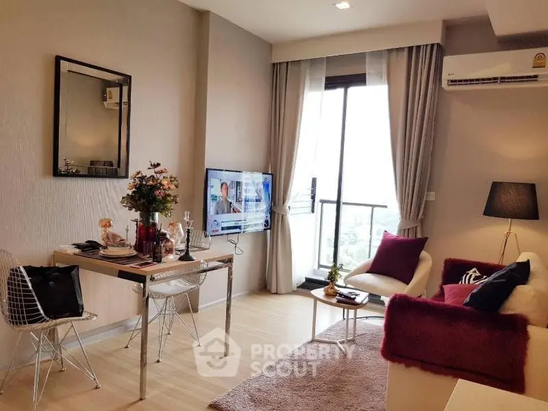 Modern living room with stylish decor and natural light, featuring a cozy seating area and wall-mounted TV.
