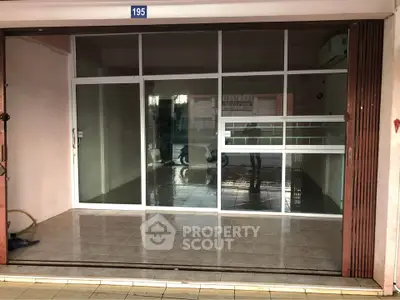 Spacious commercial space with glass facade and tiled flooring, ideal for retail or office use.