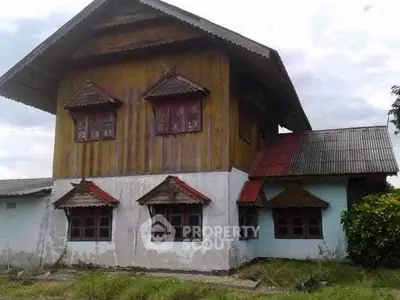 Charming rustic house with unique wooden architecture and multiple windows.