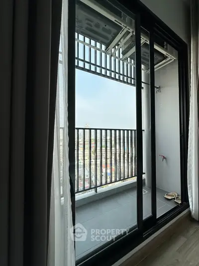 Modern apartment balcony with city view and sliding glass doors