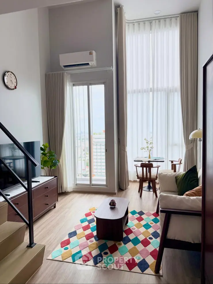 Modern living room with high ceilings, large windows, and colorful decor in a stylish apartment.