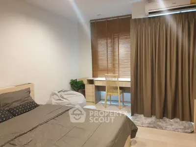 Cozy bedroom with modern decor and study area, featuring a comfortable bed and stylish curtains.