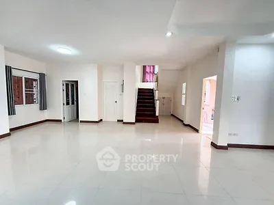 Spacious open-plan living area with staircase and natural light