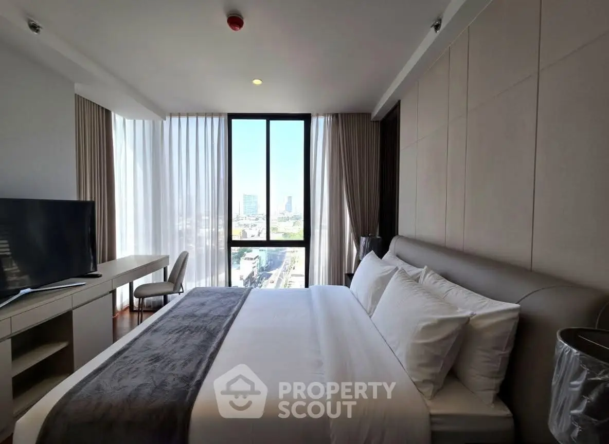 Luxurious bedroom with city view, modern furnishings, and natural light.