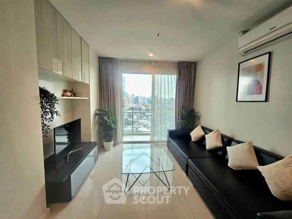 Modern living room with city view, sleek furniture, and large windows in a high-rise apartment.