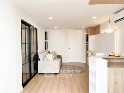 Modern living room with cozy sofa and stylish kitchen in open layout apartment.