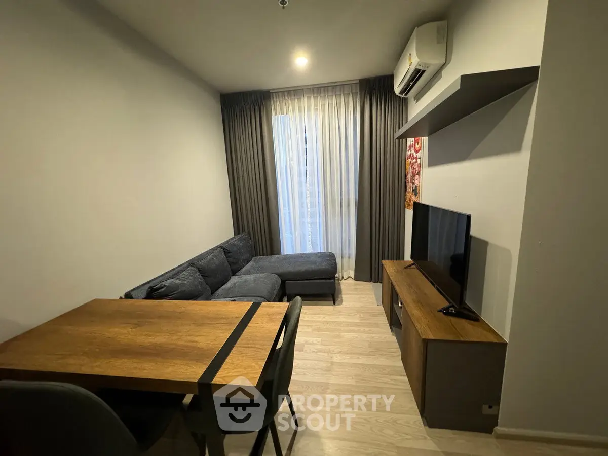 Modern living room with cozy sofa, dining table, and wall-mounted TV in stylish apartment.
