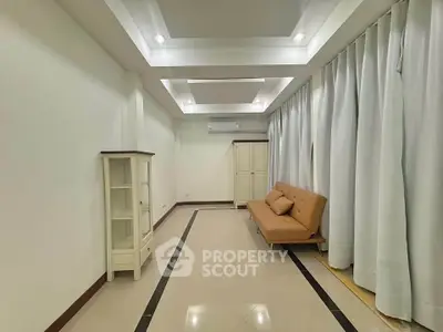 Spacious living room with modern ceiling design and elegant curtains, featuring a cozy sofa and stylish cabinet.