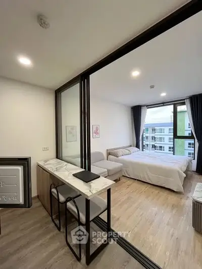 Modern studio apartment with open layout and stylish decor, featuring a cozy bed and elegant furnishings.