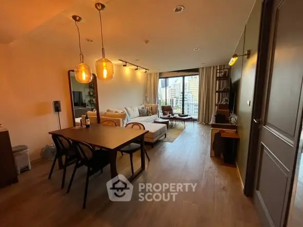 Spacious living room with city view, modern furniture, and warm lighting.