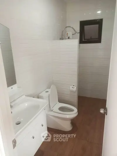 Modern bathroom with white tiles and wooden floor