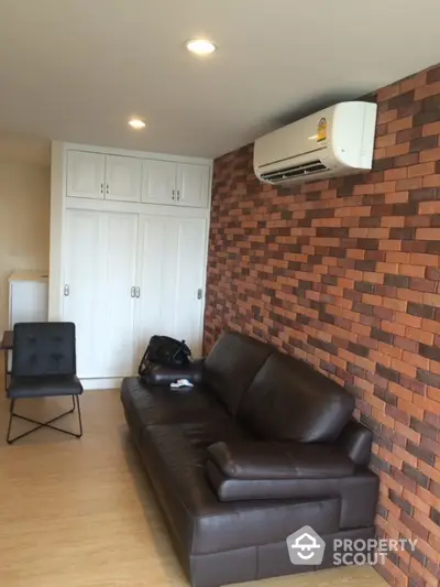 Modern living room with brick accent wall and leather sofa